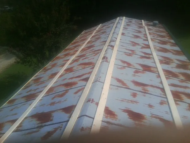 Rusted metal roof panels with new wood purlins before replacement — Storm Damage Roof Repair in Corvallis by Roofing Brothers