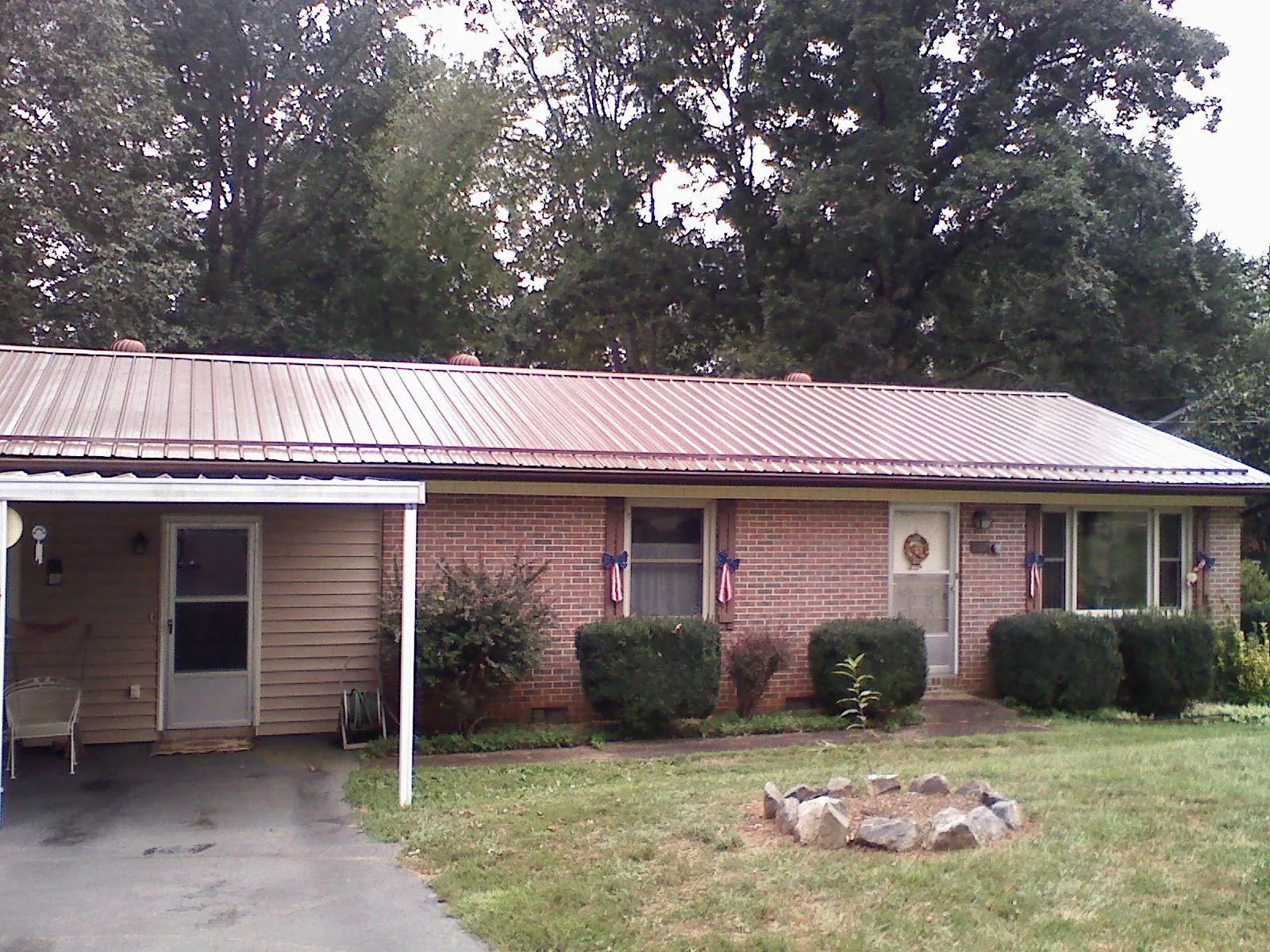 Bronze metal roof and carport on a brick ranch home — Roof Repair work by our crew in Corvallis