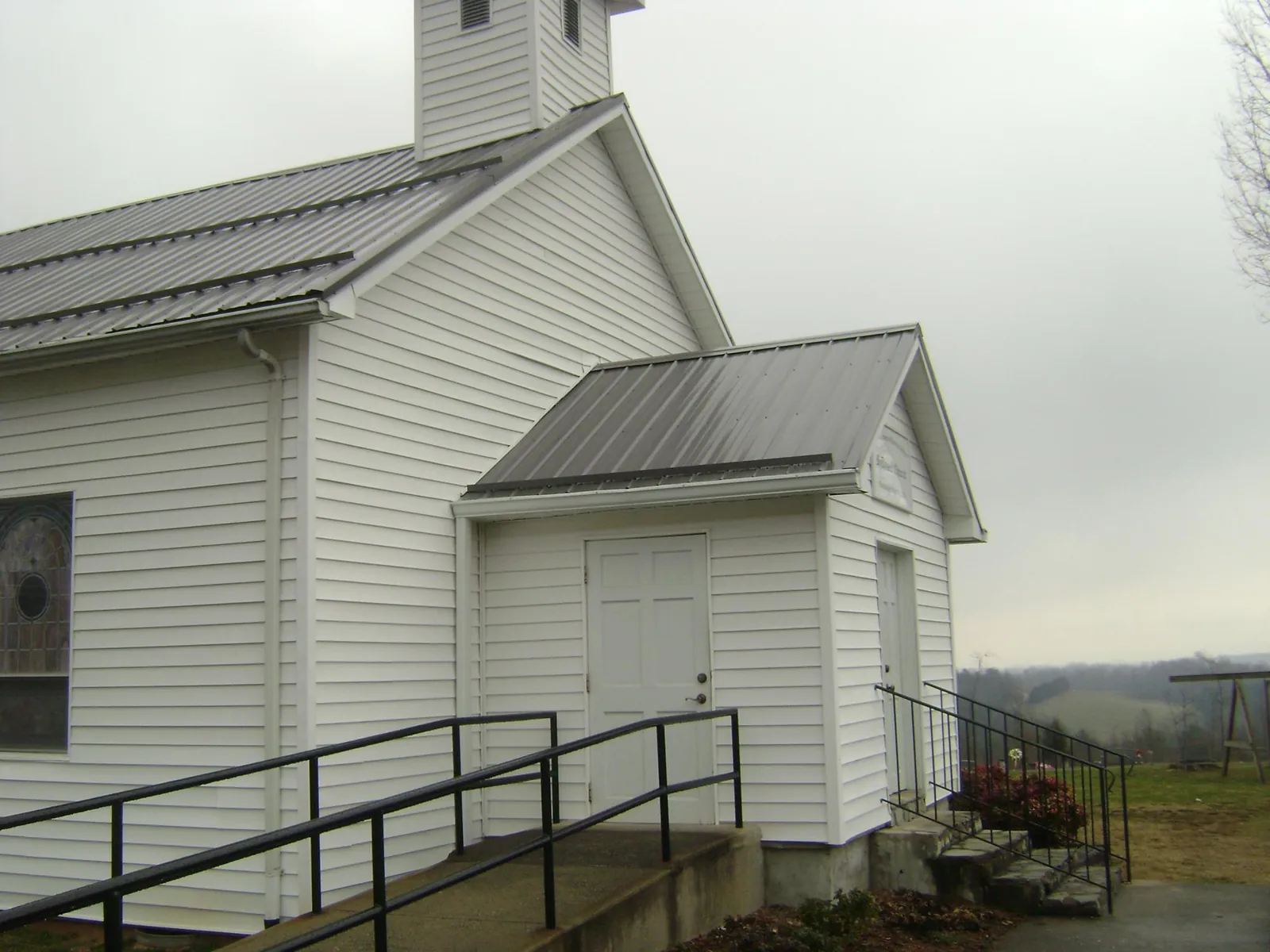Gray metal roof on a white clapboard church with a steeple in Corvallis
